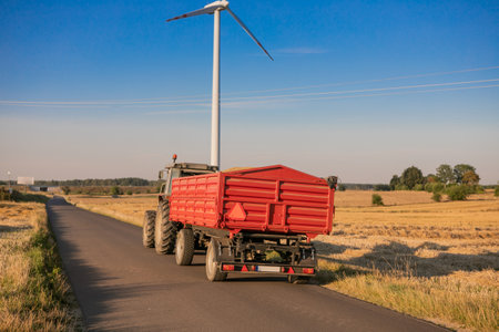 Aerial view of grain carrier on dirt road between agricultural wheat fields. Transportation of grain after being harvested by combine harvester during harvesting seasonの写真素材