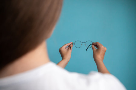 woman putting on new glasses. girl is trying on eyewear. female is taking off eyeglassesの写真素材