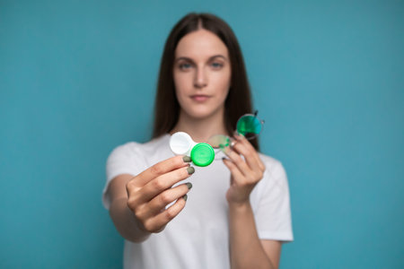woman hold contact lenses and glasses in hands. concept of choice of vision protectionの写真素材