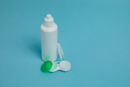 Packages with contact lenses, case, tweezers and drops on blue backgroundの写真素材