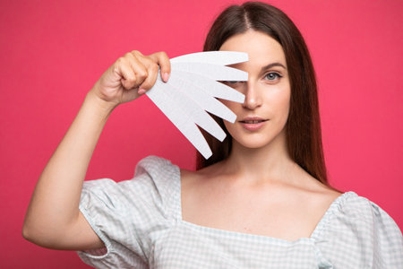 picture of young girl holding nail files near faceの写真素材