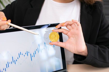 Business woman hold dogecoin actual coin in hand, background with computer laptopの写真素材