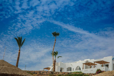 white house red sea in tropical resort whith palm and sandの写真素材