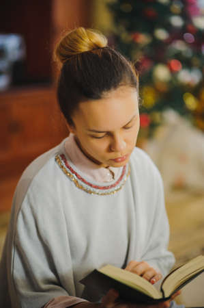 young beautiful girl reading book and smile in a vintage roomの写真素材