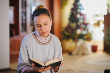 young beautiful girl reading book and smile in a vintage roomの写真素材