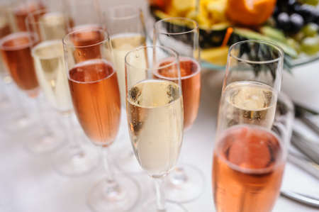 Glasses of champagne wine white and pink on the tableの写真素材