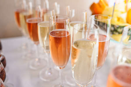Glasses of champagne wine white and pink on the tableの写真素材