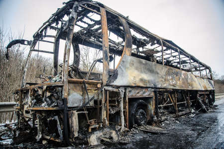 Burnt bus is seen on the street after caught in fire during travel, after fireの写真素材