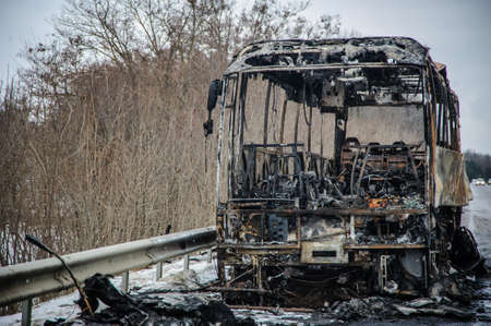Burnt bus is seen on the street after caught in fire during travel, after fireの写真素材