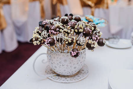 Chocolate candy balls cookies in glass vase on a partyの写真素材