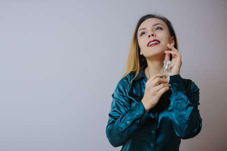 Portrait of sexy smiling happy caucasian young woman applying perfume の写真素材