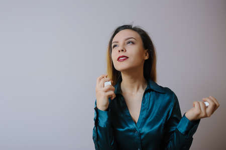 Portrait of sexy smiling happy caucasian young woman applying perfume の写真素材