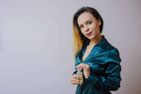 Portrait of sexy smiling happy caucasian young woman applying perfume の写真素材