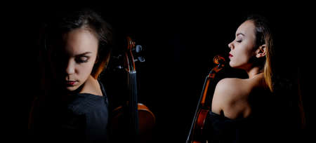 Beautiful young woman playing violin over black backgroundの写真素材