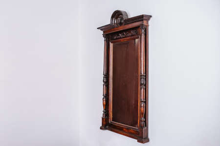 Vintage old wood mirror on a white wall in a roomの写真素材