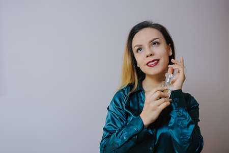 Portrait of sexy smiling happy caucasian young woman applying perfume の写真素材