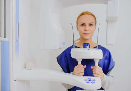 Close up of woman patient doing panoramic teeth x-ray in dental clinic in protective clothes. ortopantomographyの写真素材