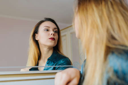 Young sexy woman looking in the mirror and smiling の写真素材