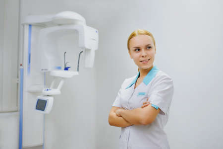 Portrait of female dentist smiling in panoramic teeth x ray orthopantomography officeの写真素材
