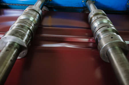 Metal tile manufacturing factory. Steel sheet metal roll profiling forming machine with rollsの写真素材
