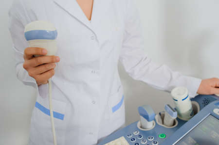 Ultrasound examination. Doctor keep holding in her hand an ultrasound transducer. Close up.USG machine の写真素材