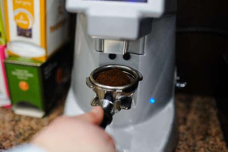 Closeup barista grinding fresh coffee into bayonet.の写真素材