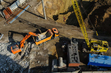 Industrial truck loader excavator moving earth and unloading into a dumper truck and bulldozer is moving groundの写真素材