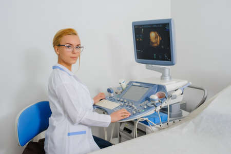 portrait of young beautiful woman doctor working at ultrasound diagnostic machine usg.の写真素材