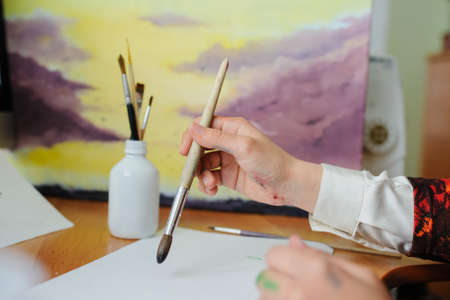 Female hand artist paint with brush a new pictureの写真素材