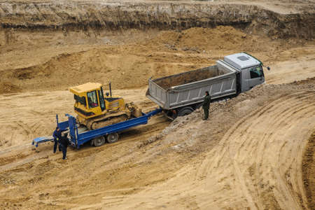 truck is moving a bulldozer to a construction siteの写真素材