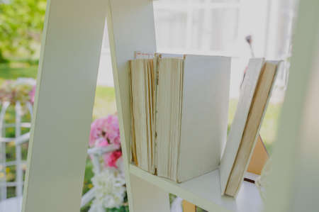 Wedding composition decoration with white books on wooden shelfの写真素材