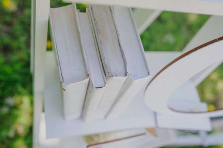 Wedding composition decoration with white books on wooden shelfの写真素材