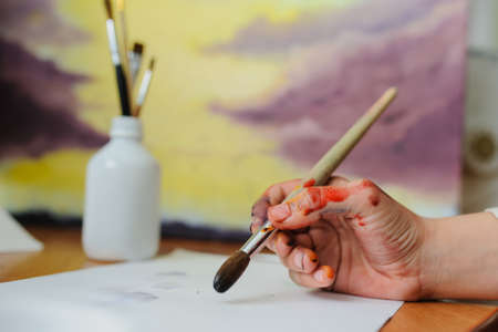 Female hand artist paint with brush a new pictureの写真素材