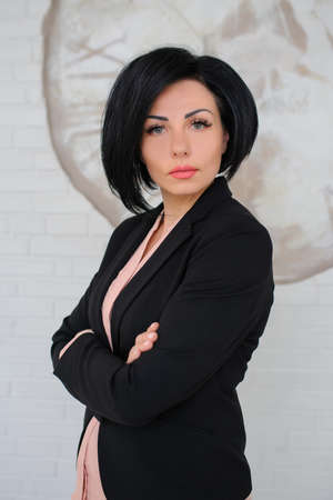 portrait of beautiful  business lady (woman/girl) dressed in black suit in a vintage cafe/officeの写真素材