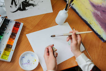 Female hand artist paint with brush a new pictureの写真素材