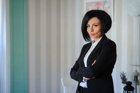 portrait of beautiful  business lady (woman/girl) dressed in black suit in a vintage cafe/officeの写真素材