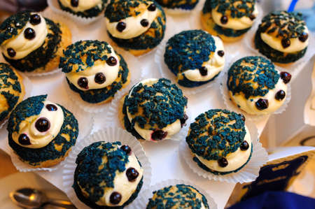Sweet cookies muffins basket with cream in a paper wrapper decorated with currantの写真素材