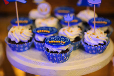 Sweet cookies muffins basket with cream in a paper wrapper decorated with gold, royal styleの写真素材