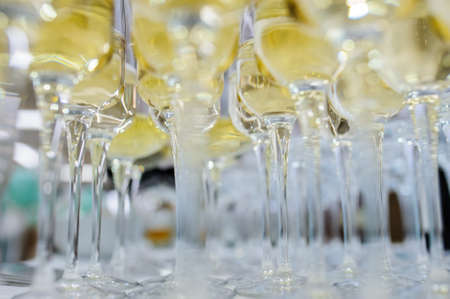 Composition from rows of glasses filled with champagne that are lined up ready to be served on a wedding reception in restaurantの写真素材