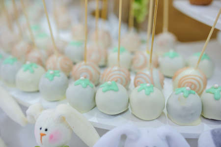 Close-up candy bar from white blue turquoise cookies balls pops on stick on a partyの写真素材