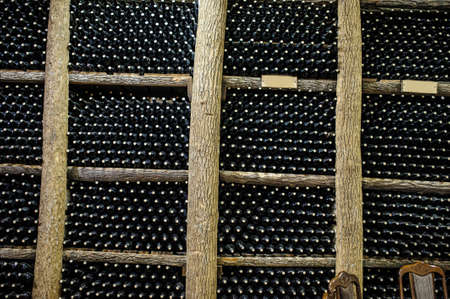 Wine cellar with bottles on wooden shelvesの写真素材