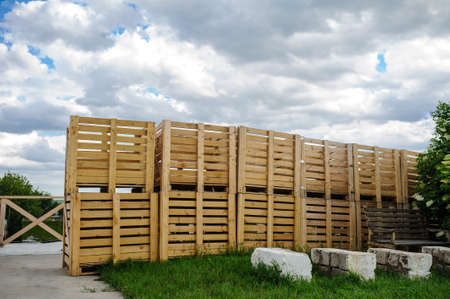 Wood pallets arranged in row, and blue sky behindの写真素材