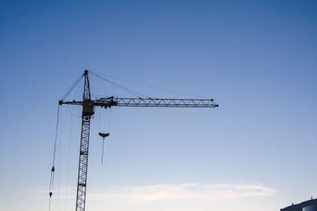 tower cranes silhouette at construction site on blue skyの写真素材