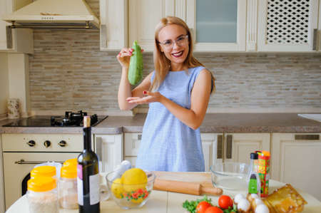 happy housewife cooking in her kitchen and smileの写真素材