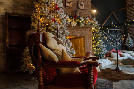 close up composition of vintage red chair in an christmas studio with fireplace and tree.の写真素材