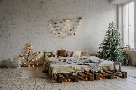 White vintage room, decorated for christmas with: pellets bed, tree with presents and toys, Christmas Balls, and big window.の写真素材