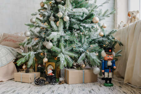 Close up christmas tree with presents and toys, balls, and artificial snowの写真素材