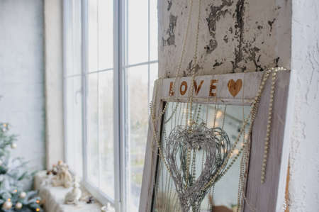 Vintage style interior decorated with  christmas tree and old mirror with love inscriptionの写真素材