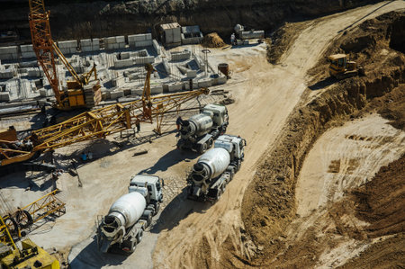 white mixers and yellow crane at the construction site of a building in summer days
