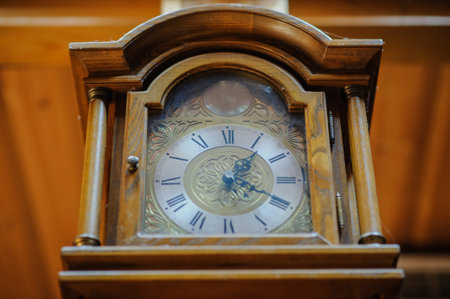 Antiquarian wooden clock with a pendulum in a retro interior